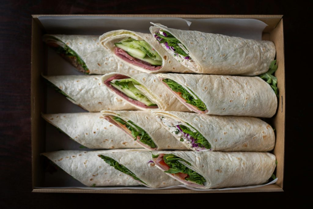 Appetizing wraps arranged in a box, showcasing fresh ingredients from a top view.